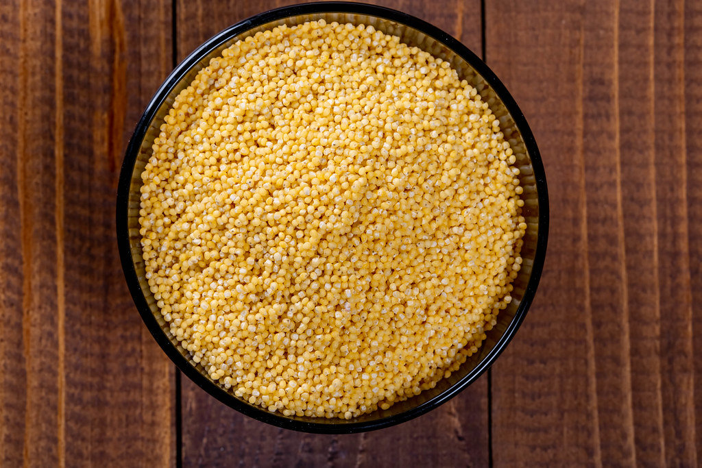 Fresh organic millet in a bowl, Top view.