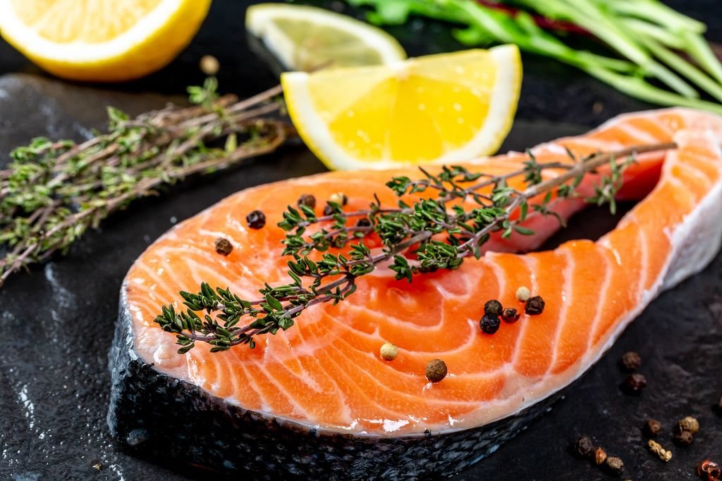 Schließen Sie oben vom rohen Lachs mit frischen Thymian- und Zitronenscheiben