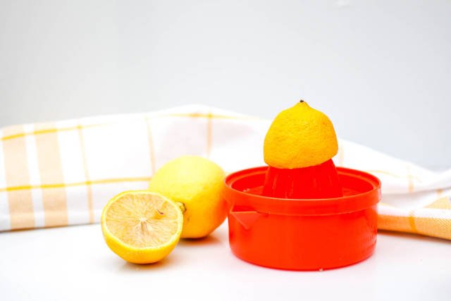 Rote Zitronenpresse und Zitronen