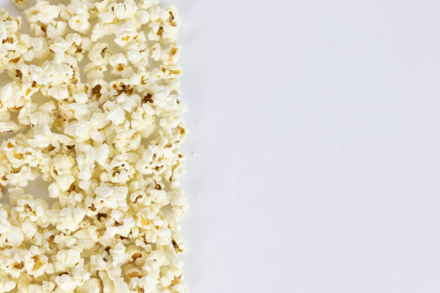 Salted popcorn grains on the white background