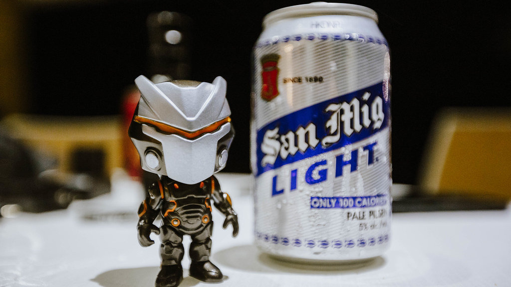 Small Toy beside a Can of Beer
