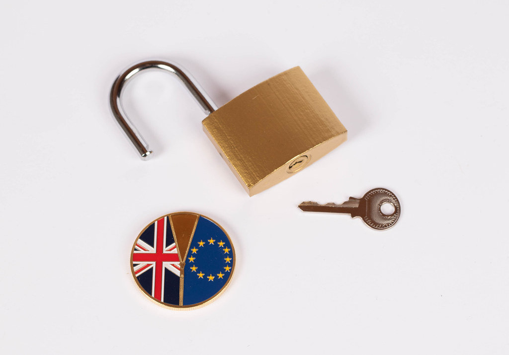 Brexit medal coin with open padlock and key on white background