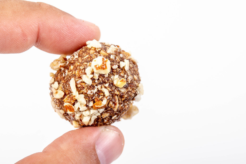 Preparing heatly Oatmeal cookie balls with Almonds in the hand