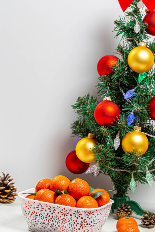 Decorated Christmas tree with a box of ripe tangerines