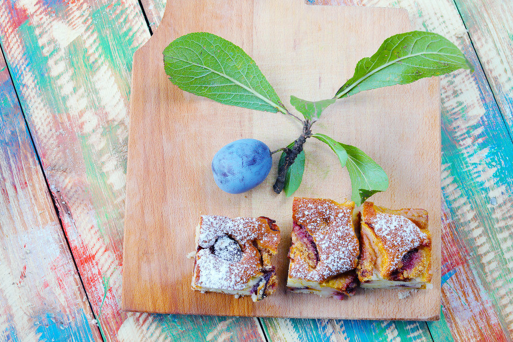 Plum cakes with fresh plum fruit on a wooden background
