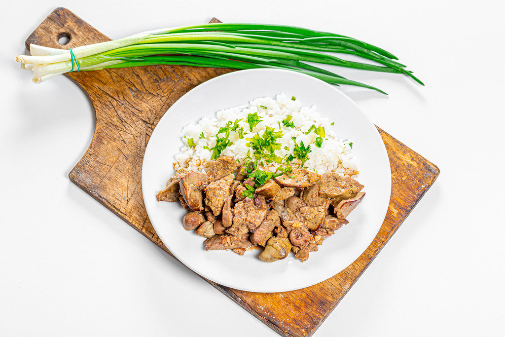 Braised chicken liver with hearts and boiled rice with fresh onion and parsley