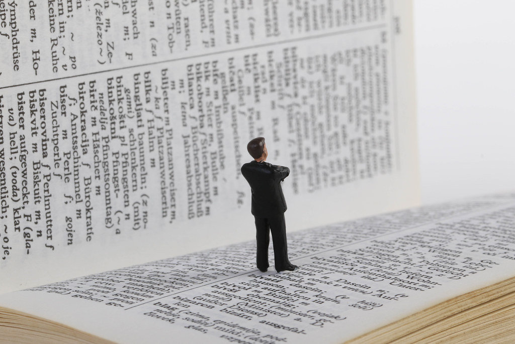 Businessman figure standing on book