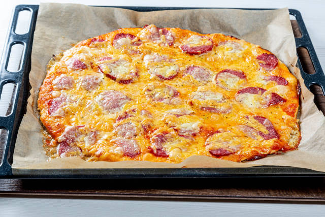 Large fresh pizza with smoked sausage and mozzarella