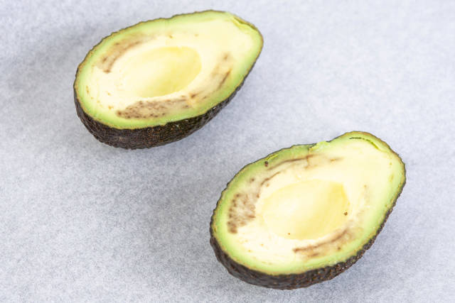 Avocado sliced on the half on the baking paper