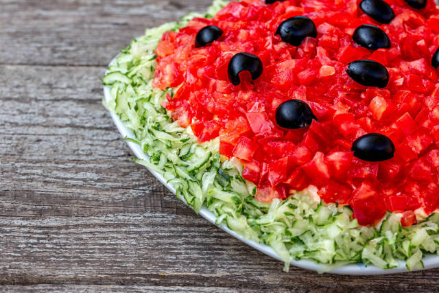 Fresh salad with tomatoes, cucumbers and black olives close-up