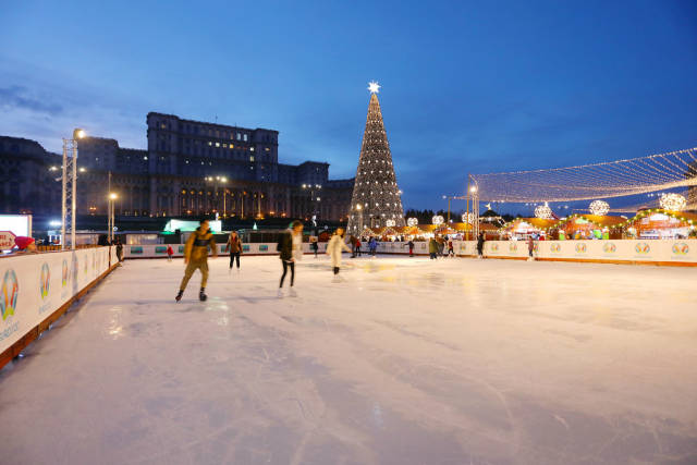 Skate rink at Bucharest Christmas market, The Palace of Parliament on background