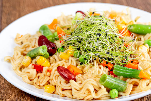 Pasta with micro-green onions, peas, asparagus, corn, carrots and beans