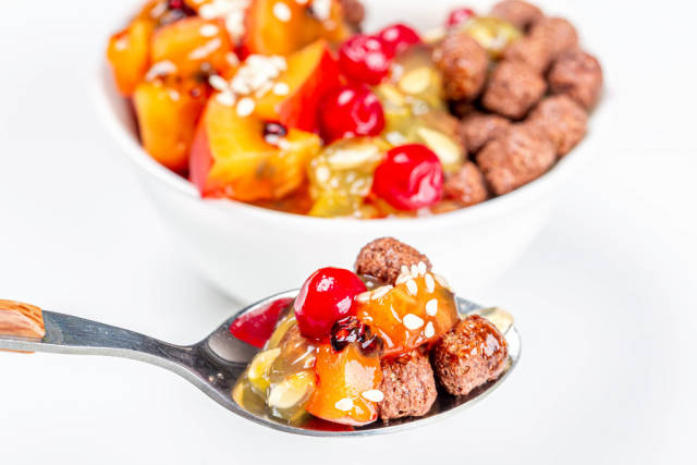 Spoon with chocolate corn balls and fruit slices