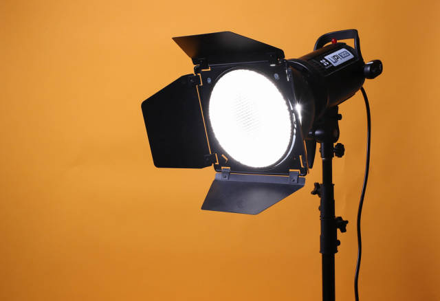 Photo studio strobe flash on orange background