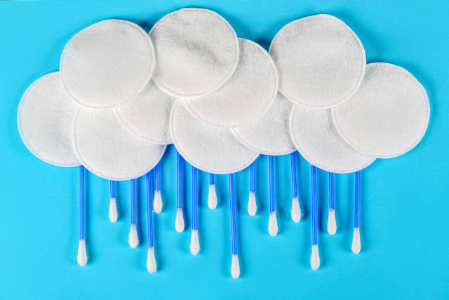 A cloud of cotton pads and a rain of ear sticks on a blue background