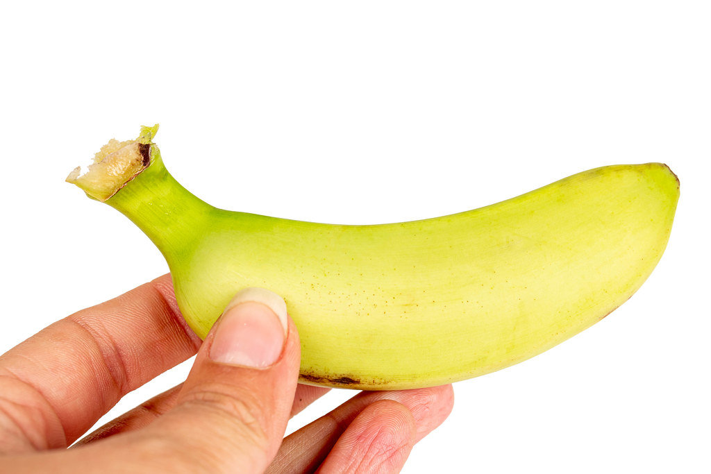Small fresh banana in a female hand