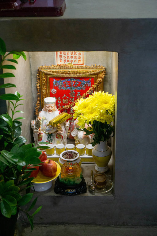 Buddhist Altar with God of Wealth, God of Land and Offerings in a Cafe in Vietnam