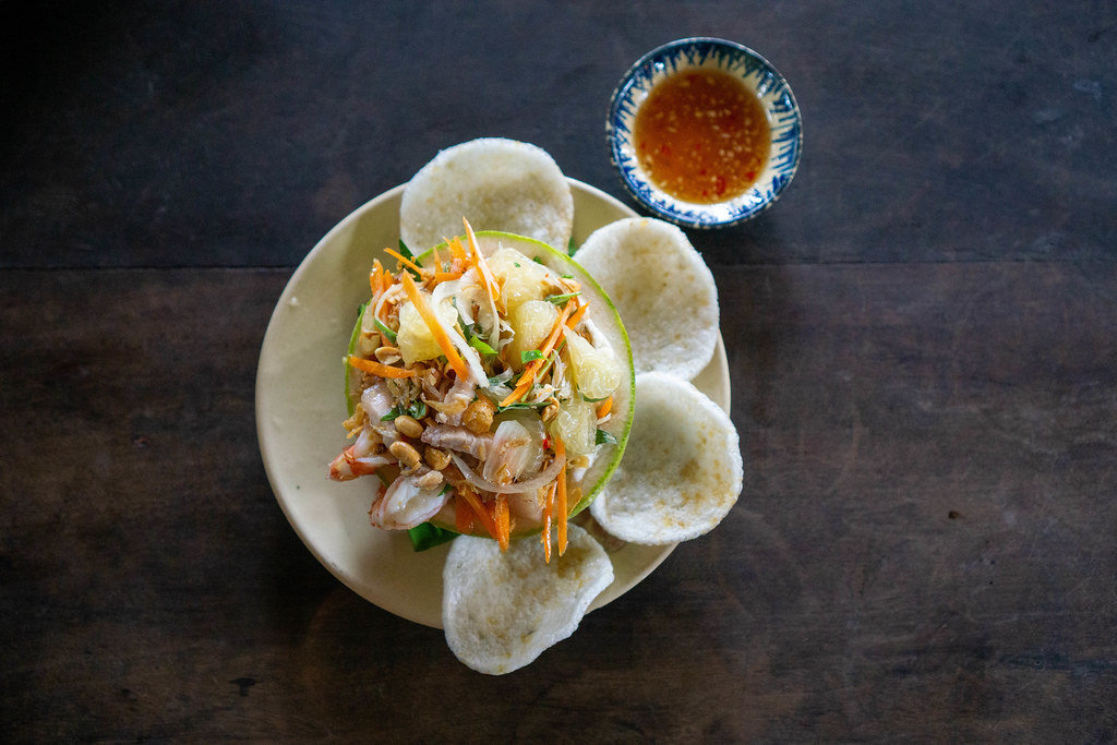 Pampelmuse Salat mit frischem Gemüse, Erdnüssen, Krabbenchips, Speck und Garnelen mit zubereiteter Fischsauce in einem Vietnamesischen Restaurant