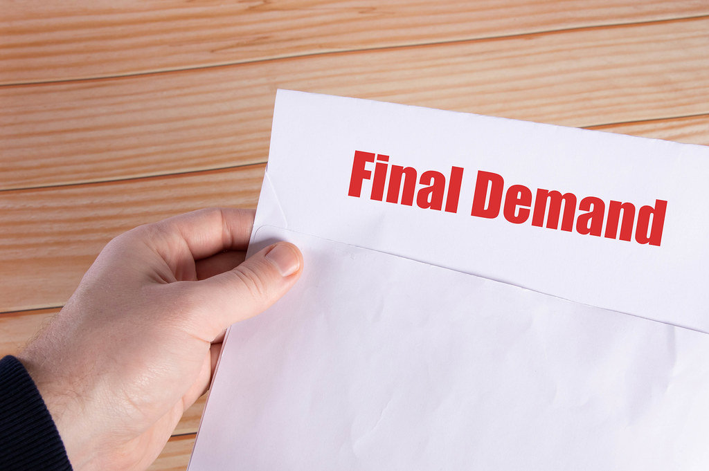Hand holding open envelope with Final Demand text
