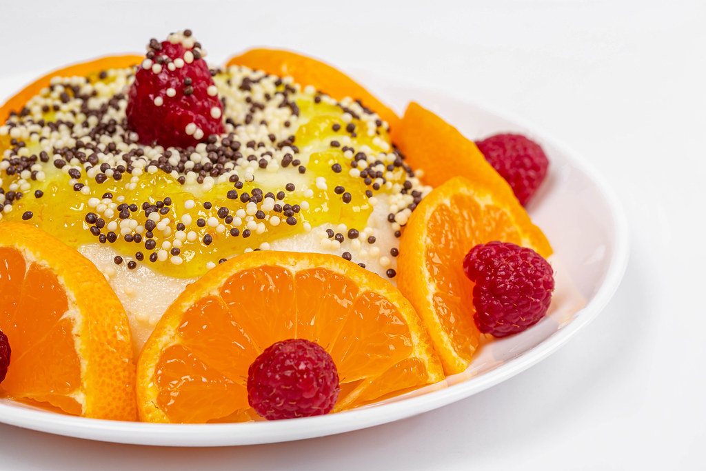 Close-up, pudding with slices of tangerine and raspberry