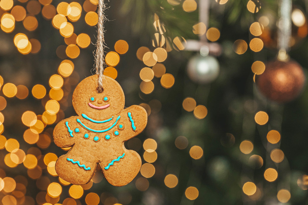 Christmas gingerbread man on blurred background of glowing garlands