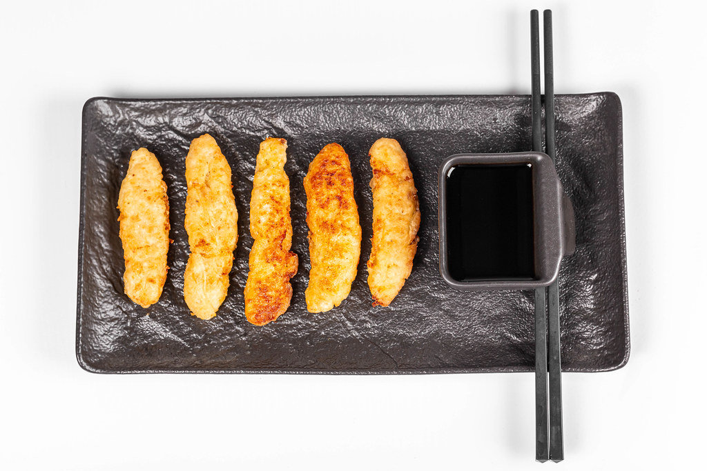 Top view, fried fish sticks with soy sauce and chopsticks