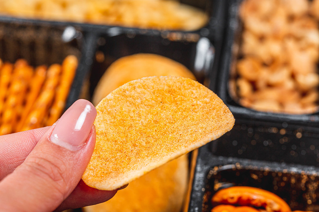 Chips in a womans hand close - up on the background of beer snacks