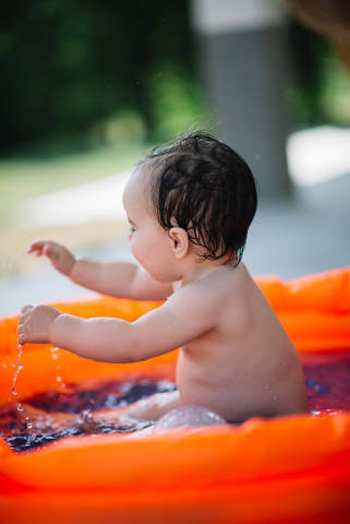 Happy baby having fun in a pool