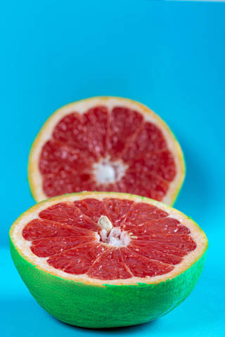 Close-up cut ripe grapefruit on blue