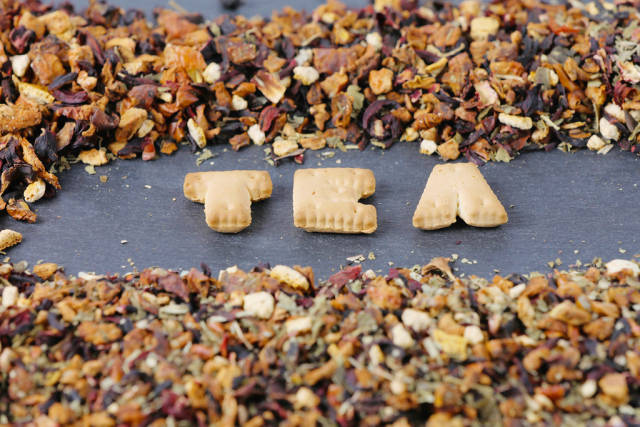Letters TEA and dry tea leaves
