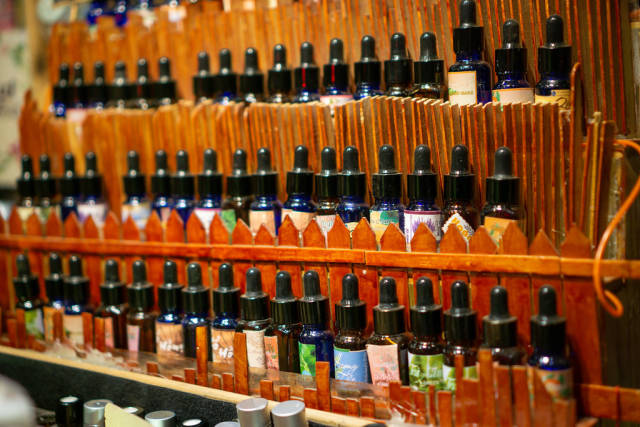 Different Essence Oils displayed on a Wooden Shelf in a Shop