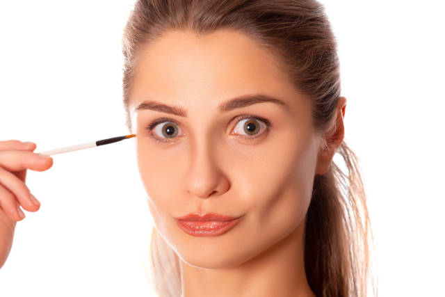 Portrait of beautiful woman with makeup brush