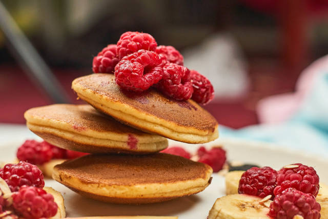 Close-up view of sweet dessert with pancakes and raspberries
