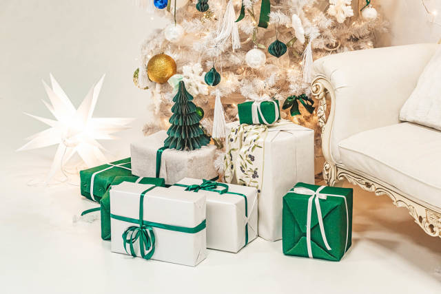 White and green gifts under the tree in the christmas room