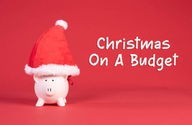 Piggy bank with Christmas hat and Christmas on a budget text on red background