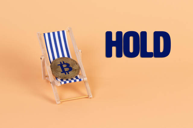 Golden Bitcoin coin lying in a deck chair with Hold text