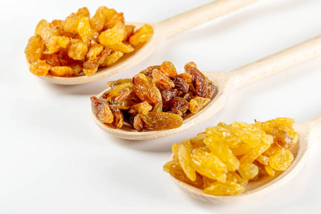 Set of various raisins in wooden spoon