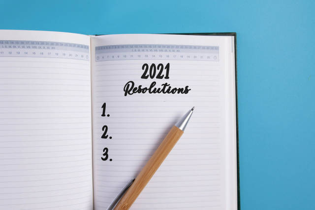 Open notebook with 2021 Resolutions list on blue background