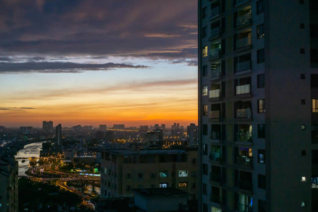 Aussicht auf den Verkehr und Distrikt 5 von Ho Chi Minh City am Abend mit farbenfrohem Himmel in Saigon, Vietnam