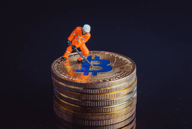 Miner working on a golden Bitcoin