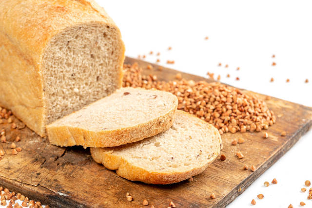 Sliced fresh buckwheat bread on a wooden kitchen board, close-up