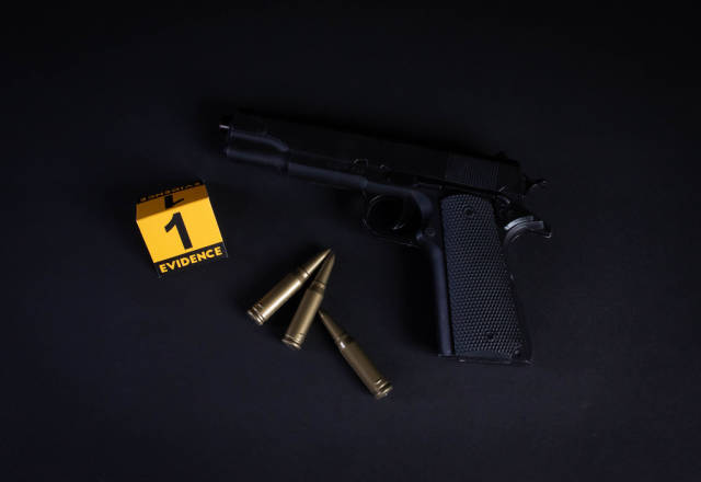 Gun and evidence marker on black background