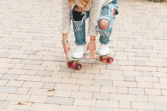 Young woman learning to skateboard