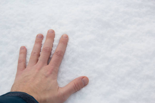 Den Schnee mit der Hand berühren