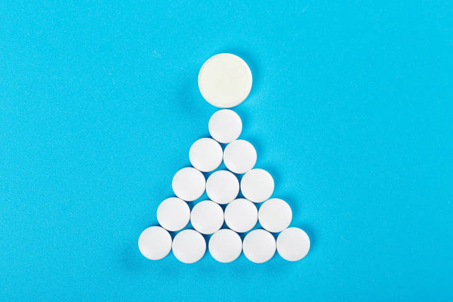 The sign or symbol of a woman is made of white tablets on a blue background