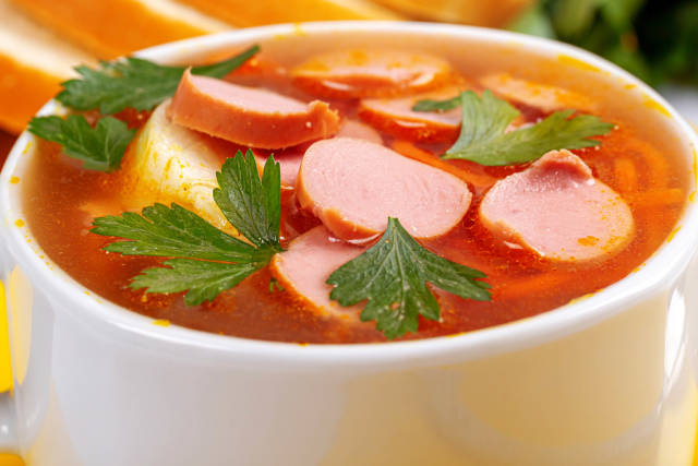 Close-up, bowl of soup with sausages and carrots