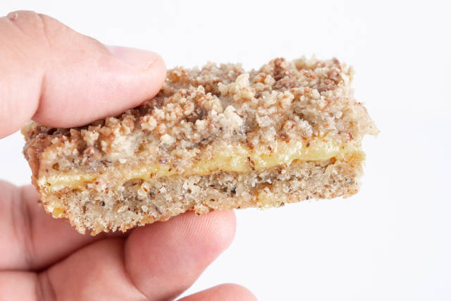 Walnuts Cake slice in the hand above white background