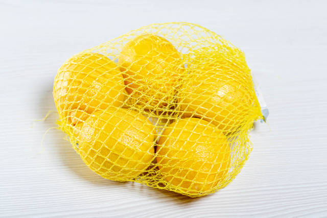 Ripe yellow lemons Packed in mesh