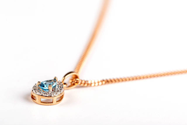 Close-up, gold pendant with topaz stone and chain