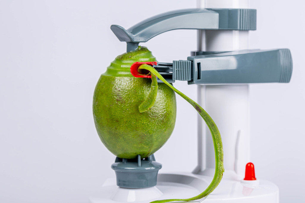 Electric fruit and vegetable peeling machine removes the skin from the avocado